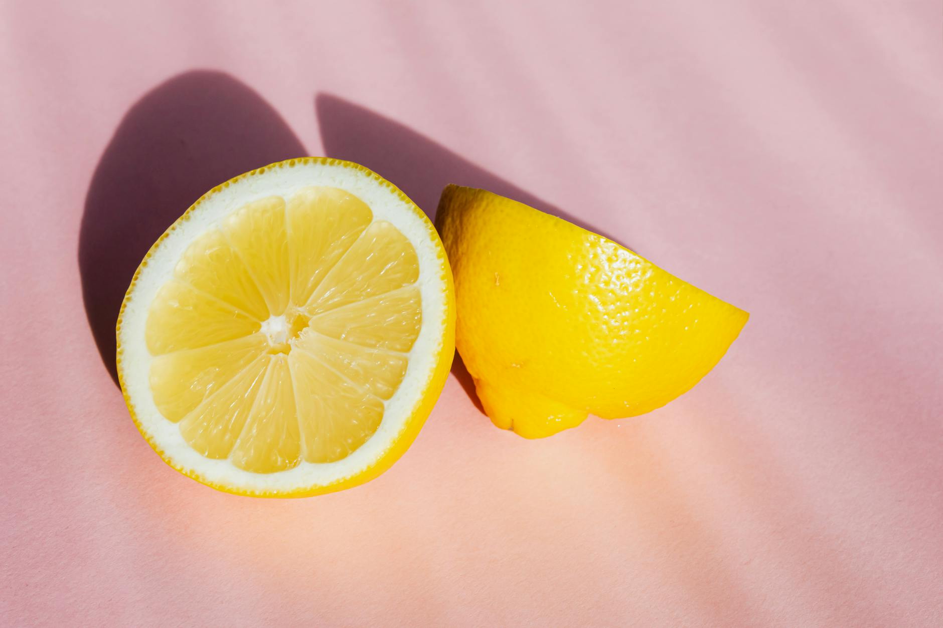 Hand holding an orange vibrator against a minimalistic purple backdrop