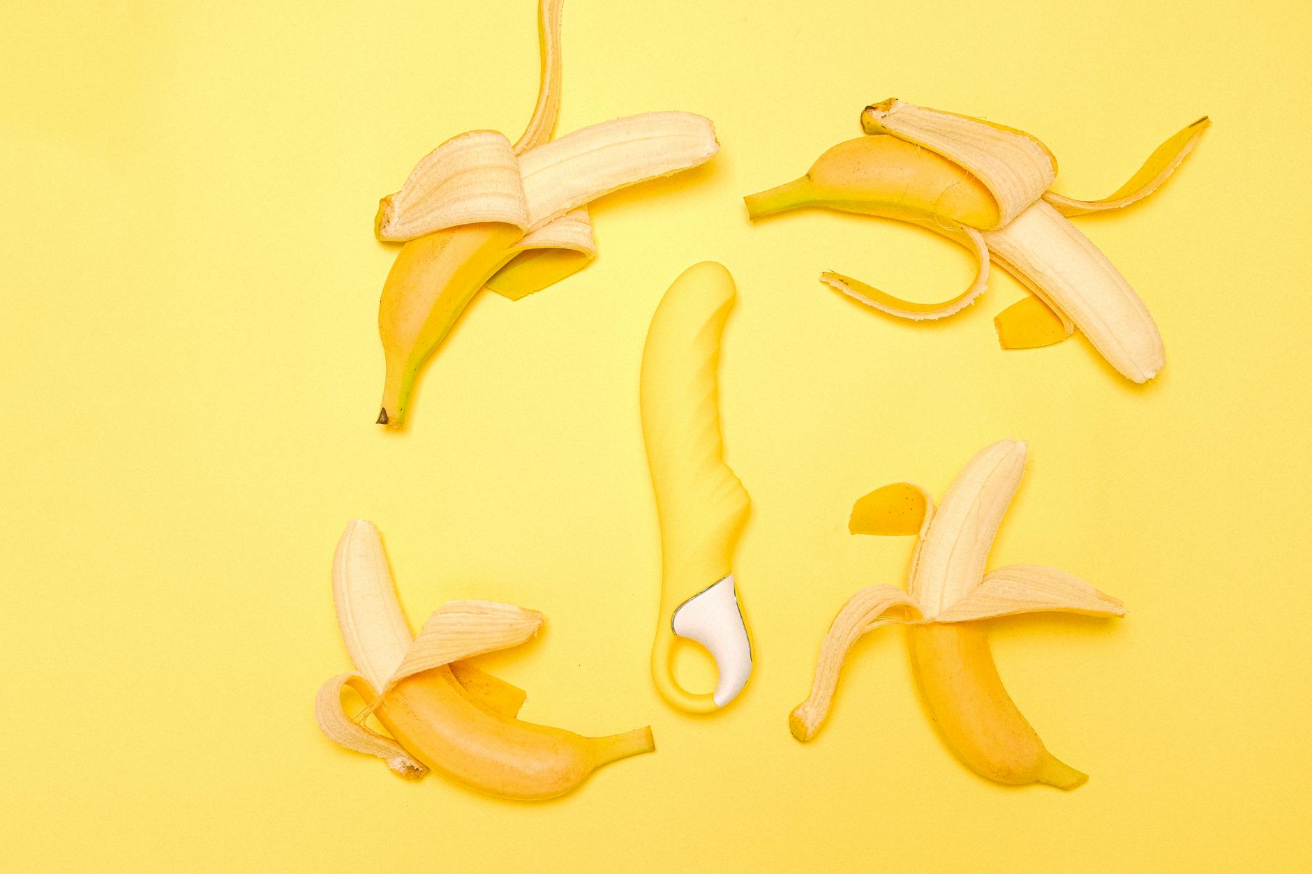 A bright yellow lemon vibrator surrounded by fresh lemons on a cheerful yellow background, representing the joyful reclamation of pleasure.