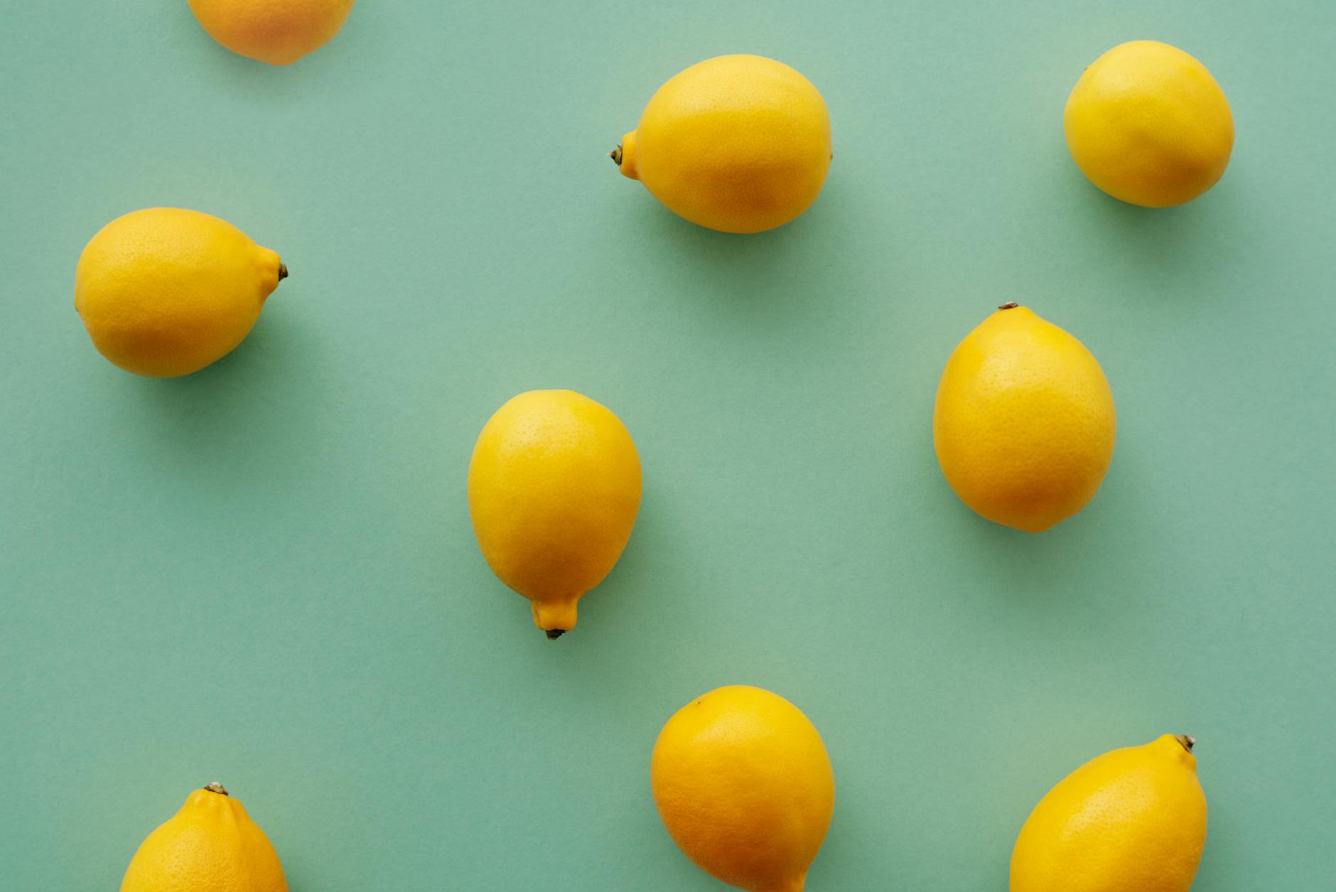 Lemon vibrator surrounded by fresh citrus and flowers on a bright yellow background