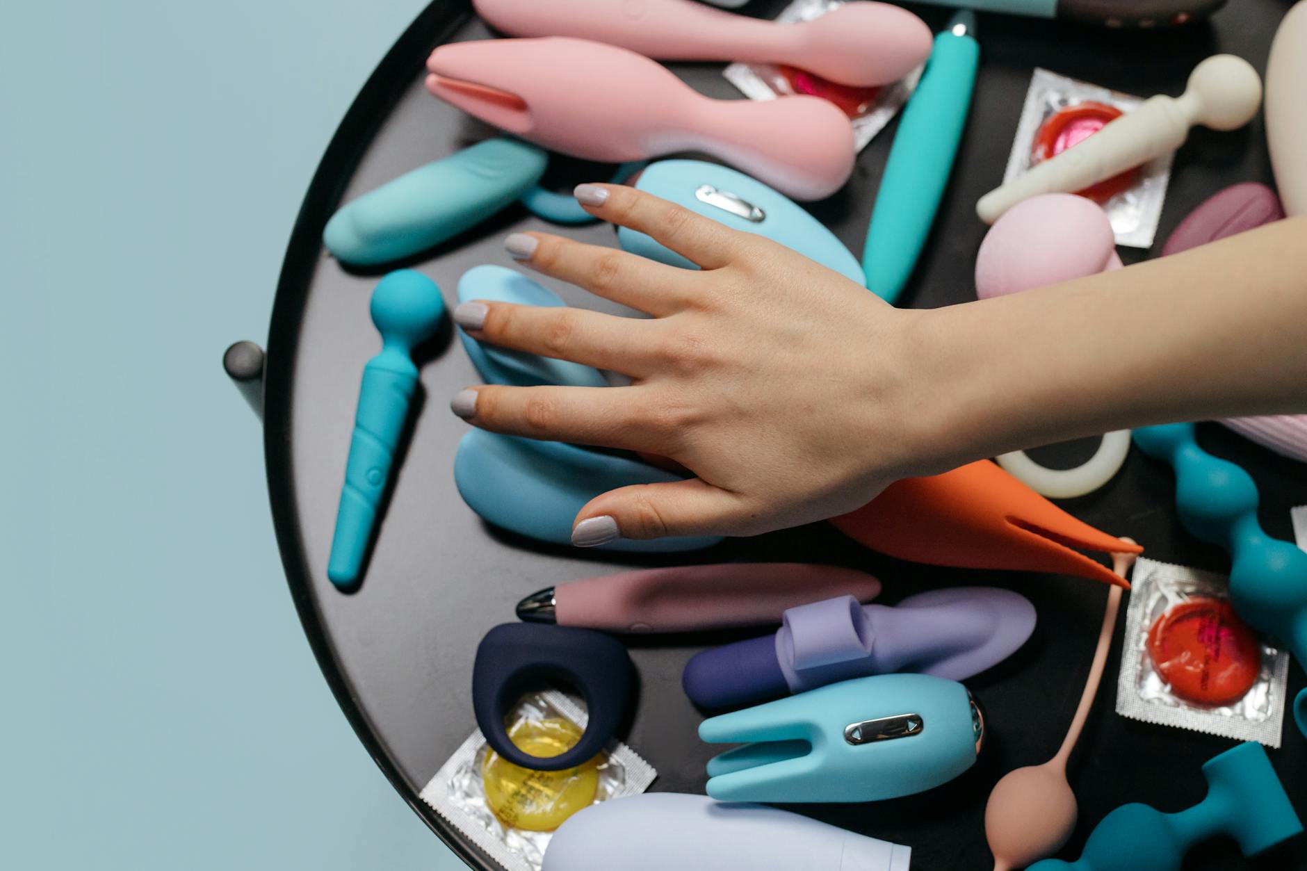 A teal lemon clitoral vibrator on smooth white silk fabric, symbolizing gentle, self-directed pleasure