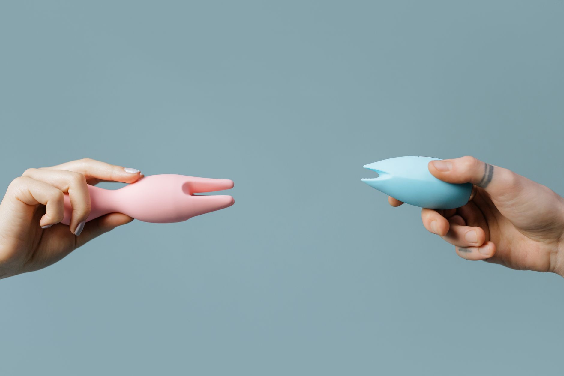 Hand holding an orange vibrator against a minimalistic purple backdrop, showcasing modern sensuality.