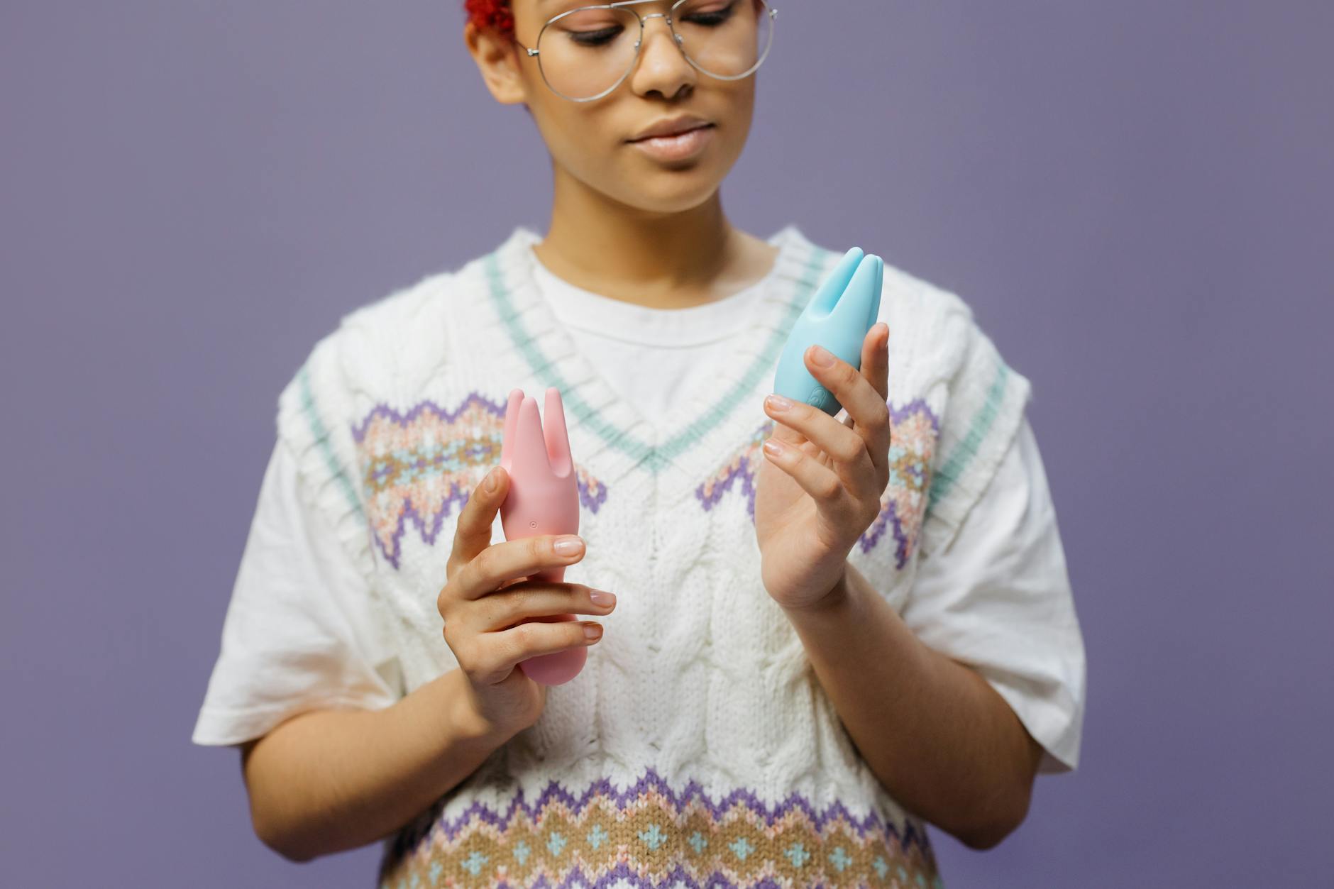 Woman holding lemon clitoral vibrators in hands, looking thoughtful and centered