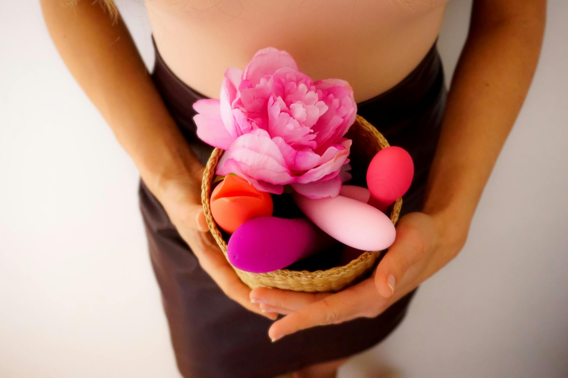 Vibrant collection of colorful sex toys arranged on a bright yellow surface