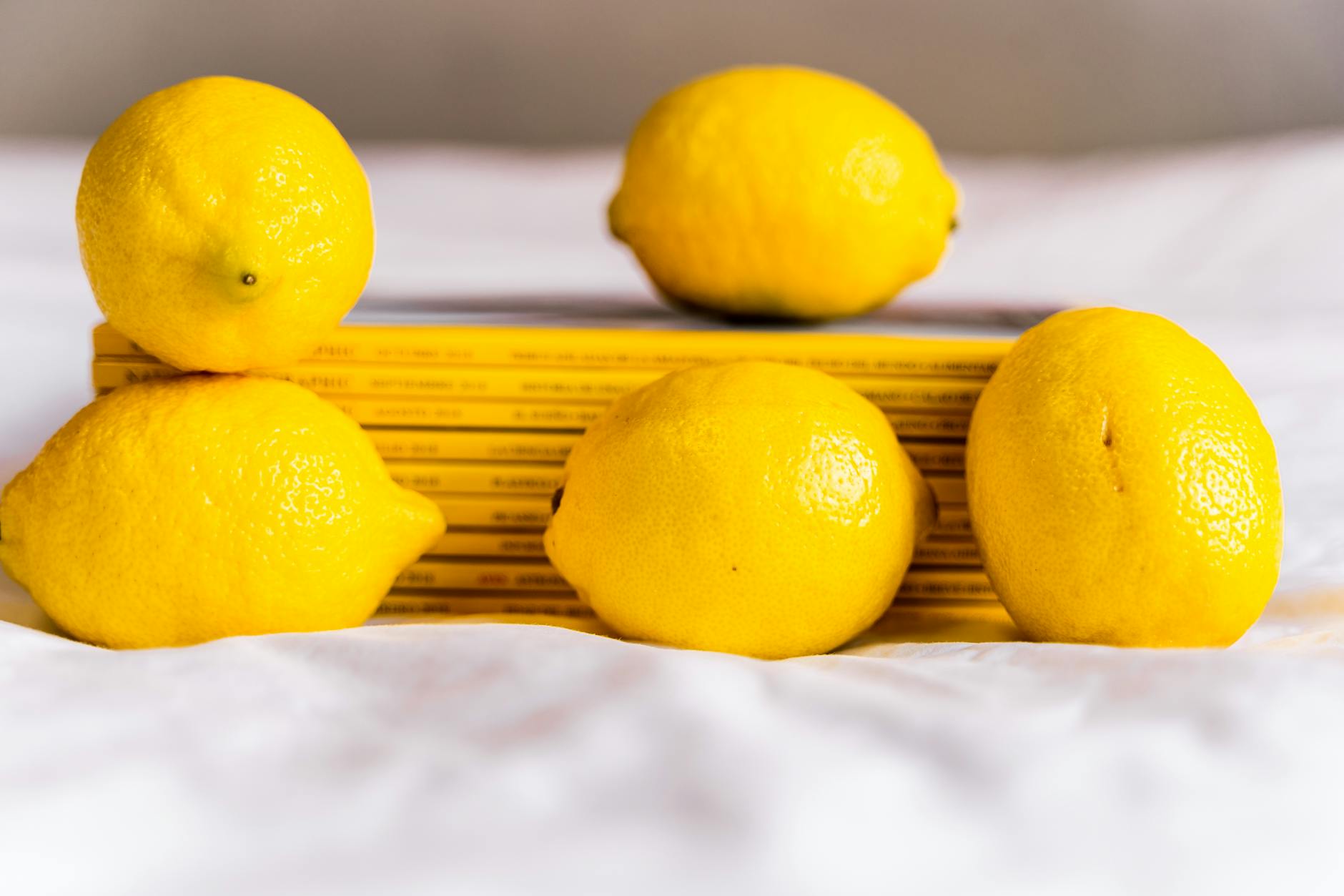 Yellow lemon vibrator surrounded by fresh fruit on a bright background